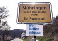 Corona-Krise: Ein Zusatzschild am Ortschild von Horb-Muehringen; Wir bleiben zuhause.