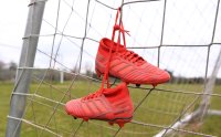 Fussball / Lokalfussball: Fussballschuhe haengen am Tornetz