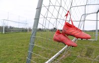 Fussball / Lokalfussball: Fussballschuhe haengen am Tornetz
