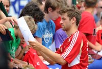 Fussball 1. Bundesliga Saison   2011/2012 : Thomas Mueller (FC Bayern Muenchen) schreibt fuer die Fans Autogramme