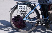 Themenbild: Radverkehr, Schild scheiss Autos an einem Gepaecktraeger eines Fahrrades