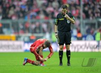 Fussball 1. Bundesliga, Saison 2011/2012: Thomas Mueller (FC Bayern Muenchen) bindet sich die Schuhe neben Schiedsrichter Michael Weiner