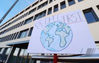 Protestplakat: People first vor dem Tuebinger biopharmazeutisches Unternehmen CureVac AG
