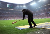 Fussball 1. Bundesliga, Saison 2011/2012:  Die Werbeflaechen auf dem Boden werden mit einem Besen gereinigt
