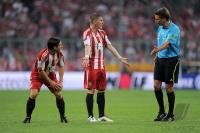 Fussball 1. Bundesliga Saison 2010/2011: Danijel Pranjic, Bastian Schweinsteiger (v. li., FC Bayern Muenchen)  Schiri Thorsten Kinhoefer