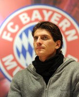 Fussball 1. Bundesliga : Mario Gomez vor dem FCB Logo (FC Bayern Muenchen)