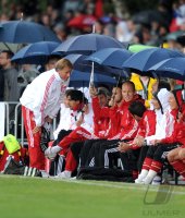 Fussball 1. Bundesliga :  Trainer Andries Jonker, Thomas Mueller, Arjen Robben (v. li., FC Bayern Muenchen) Bank mit Regenschirm