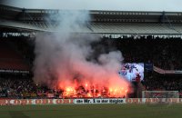 Fussball 1. Bundesliga, Saison 2011/2012:  Koeln Fankurve mit einem Bengalischen Feuer zum Fasching